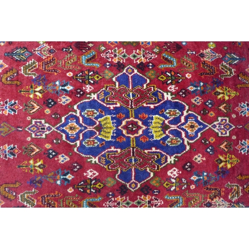 237 - Persian Qashqai rug, red foliate field with central blue medallion,  168 x 88cm