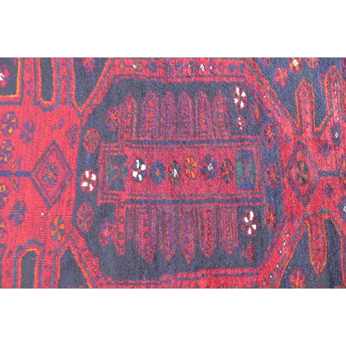 238 - Afghan wool rug, red field and flowerhead border, 188 x 143cm