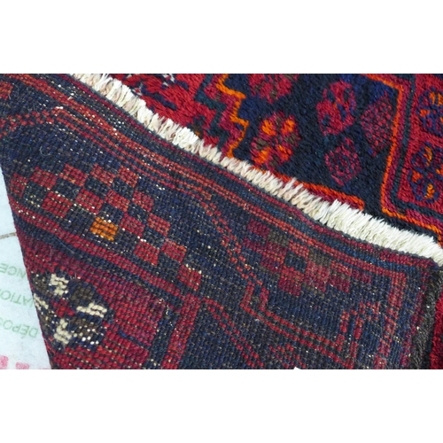 238 - Afghan wool rug, red field and flowerhead border, 188 x 143cm