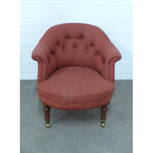 250 - An early 20th century buttonback upholstered tub armchair, mahogany legs with brass caps and castors... 