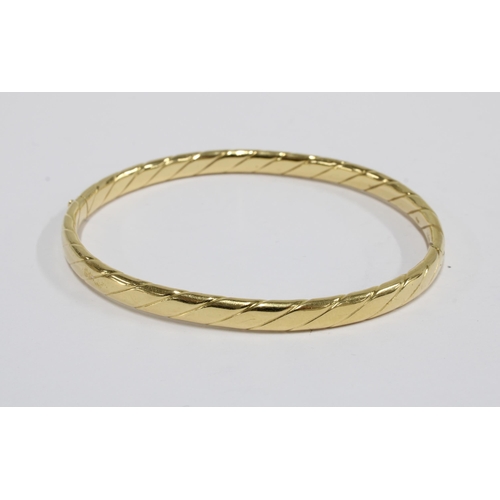 28 - 18ct gold bangle with incised design, stamped 750