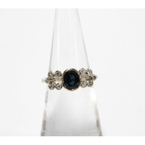 64 - Sapphire and diamond ring set in unmarked white metal, the central sapphire in a rub over collet set... 