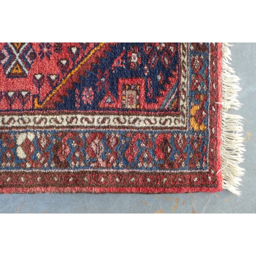 221 - Persian wool, the rug red field with a pole medallion and flowerhead border,  103 x 97cm