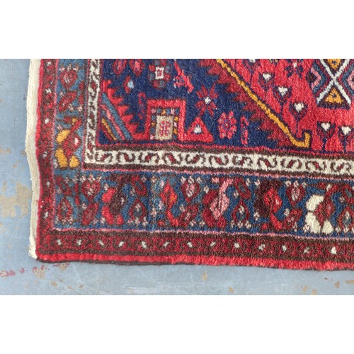 221 - Persian wool, the rug red field with a pole medallion and flowerhead border,  103 x 97cm