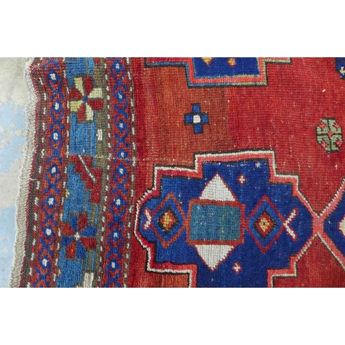 219 - Persian rug, red field with central blue medallion, 198 x 146cm