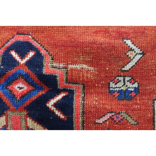 219 - Persian rug, red field with central blue medallion, 198 x 146cm