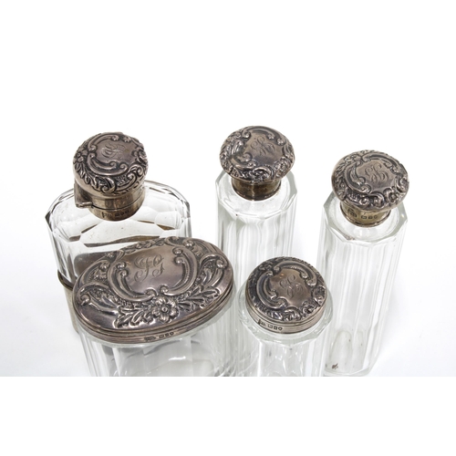 40 - An Edwardian set of Walker & Hall silver topped glass jars and bottles, London 1908 together with ma... 