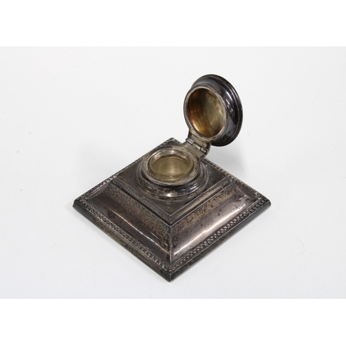 33 - George V silver inkwell, square form with hinged lid and a clear glass liner, London 1926, 8cm