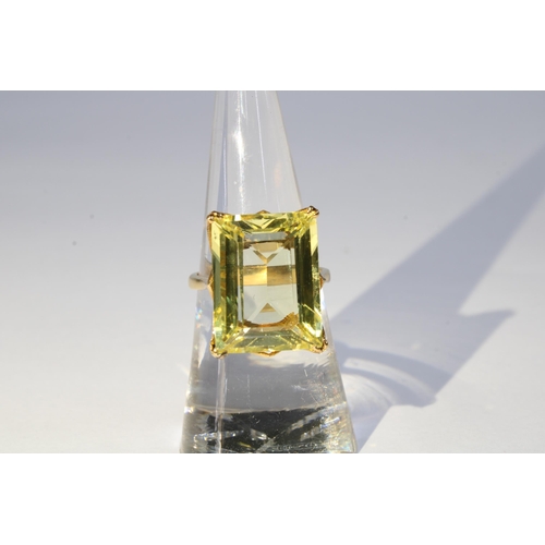 54 - Yellow sapphire dress ring, the step cut stone is claw set in unmarked yellow metal