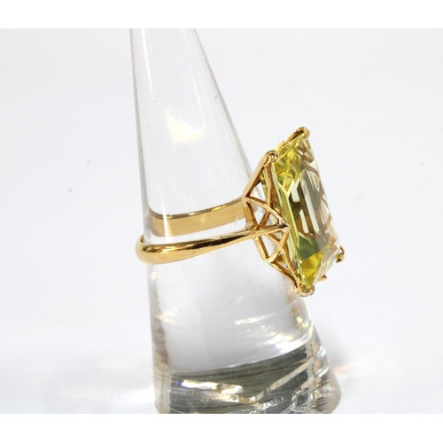 54 - Yellow sapphire dress ring, the step cut stone is claw set in unmarked yellow metal