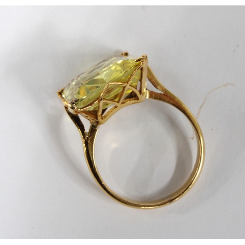 54 - Yellow sapphire dress ring, the step cut stone is claw set in unmarked yellow metal