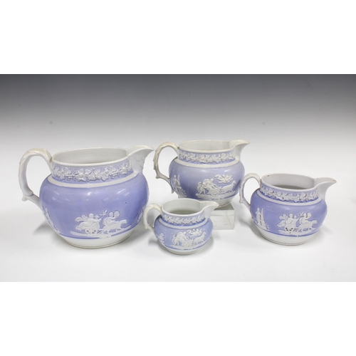 86 - A set of four Newhall graduated porcelain jugs, lavender and white with sprigged foliage and chariot... 