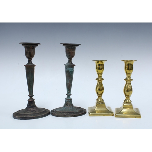 129 - Pair of worn silver plate on copper candlesticks, 20cm, together with a pair of brass candlesticks 1... 