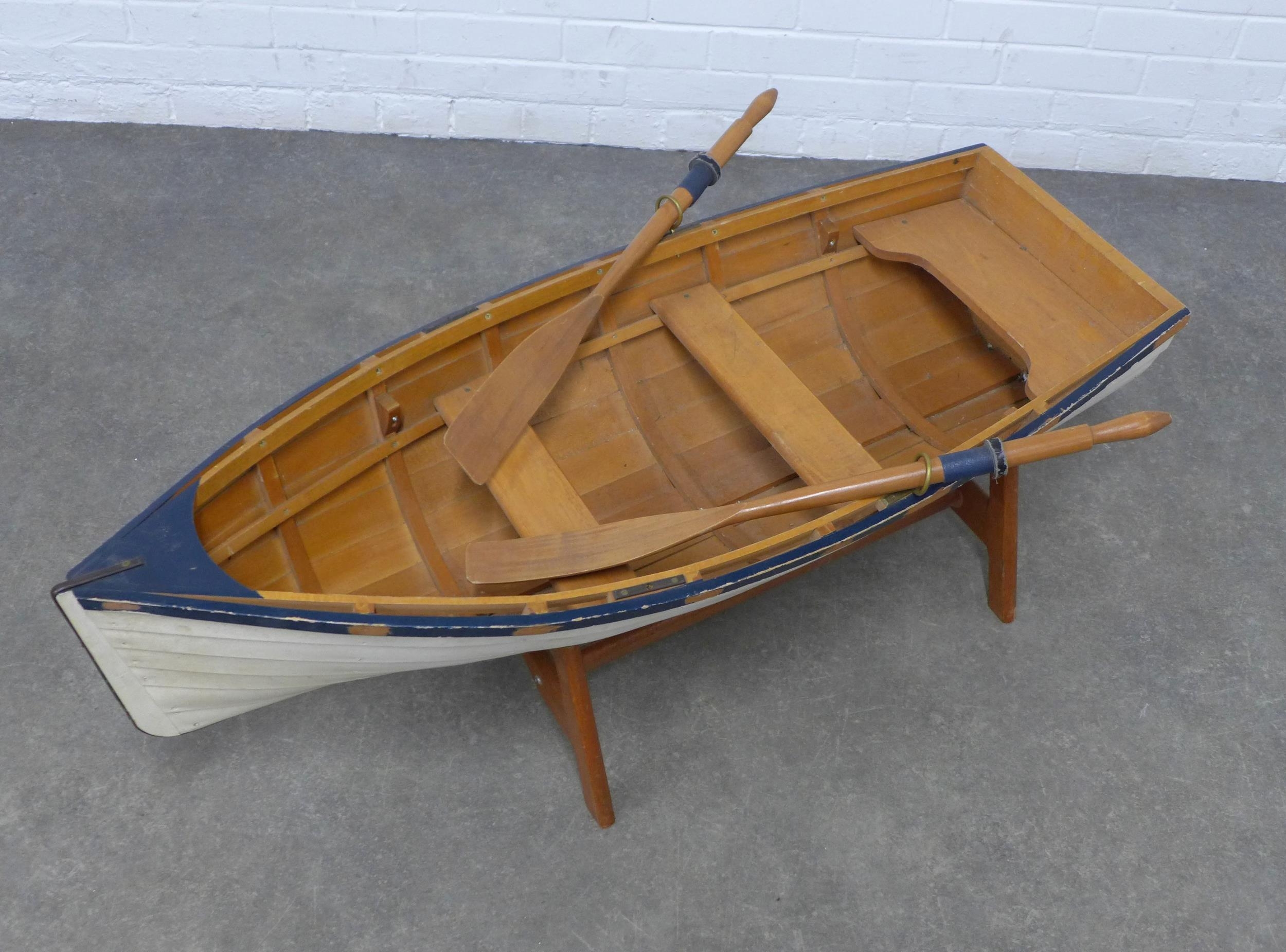 Rowing boat on stand, with blue and white painted hull, complete with a ...