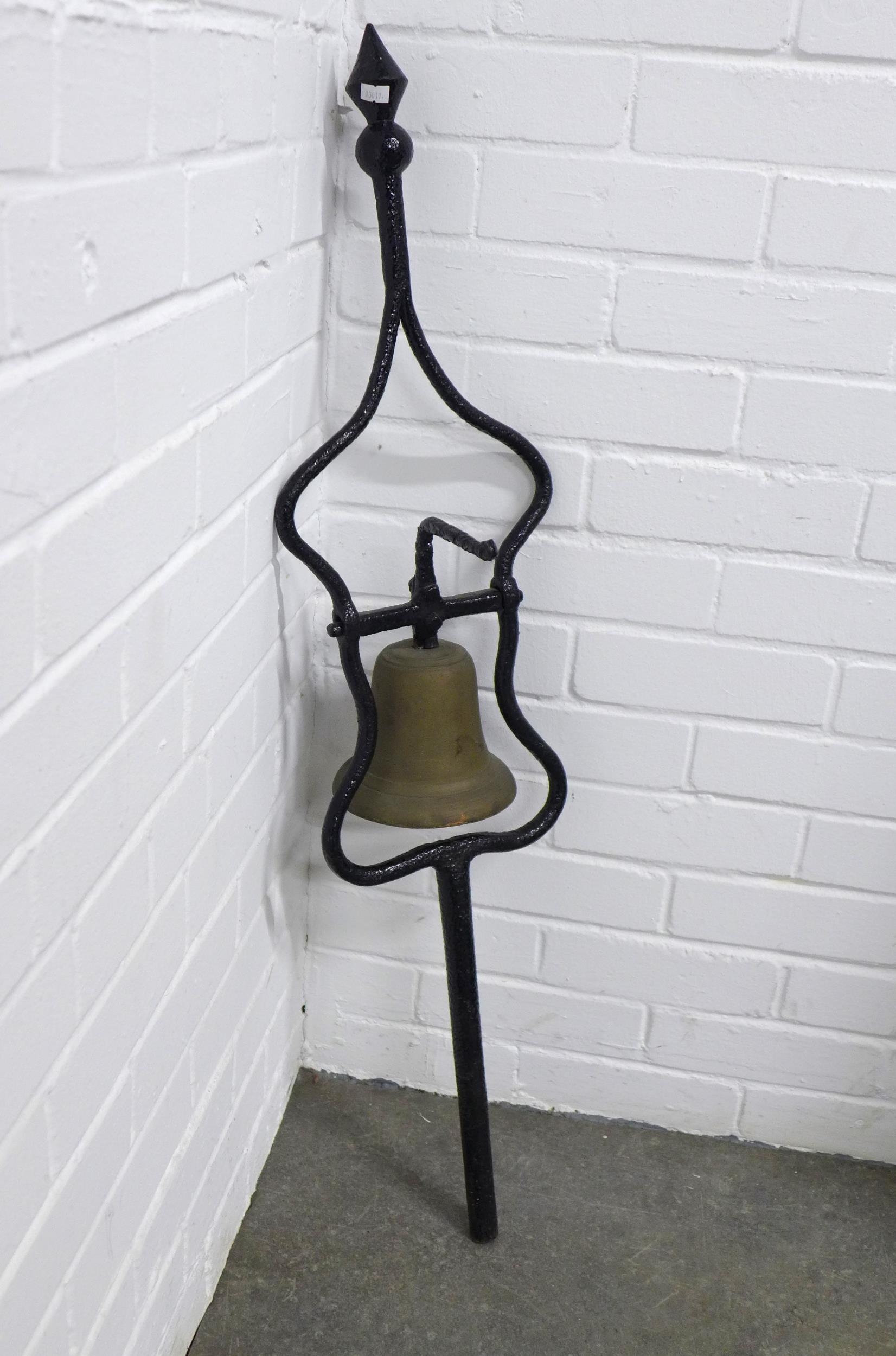 Brass bell in a wrought iron wall mount, 24 x 103cm.