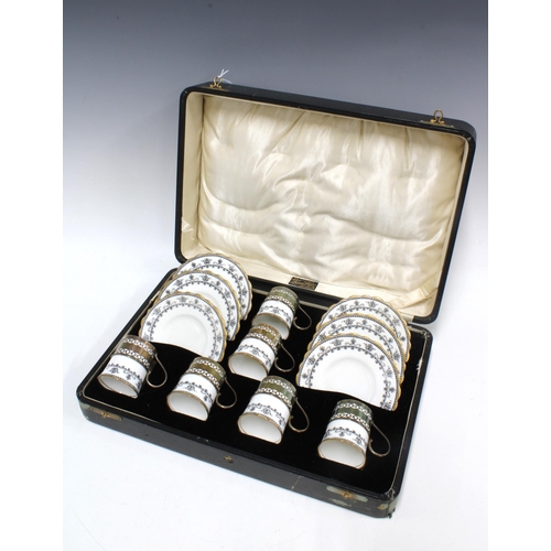 64 - A set of six hallmarked silver coffee can holders with Aynsley black and white cups and saucers, Bir... 