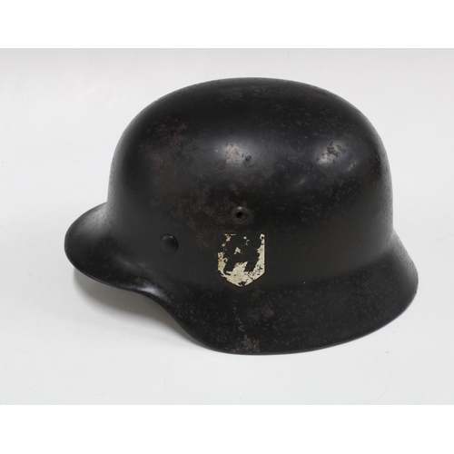 401 - German WWII steel helmet in black, with National Shield decal to one side and an indistinct decal to... 