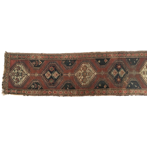 671 - A narrow runner rug, joined central lozenges surrounded by a geometric border, 71x336cm