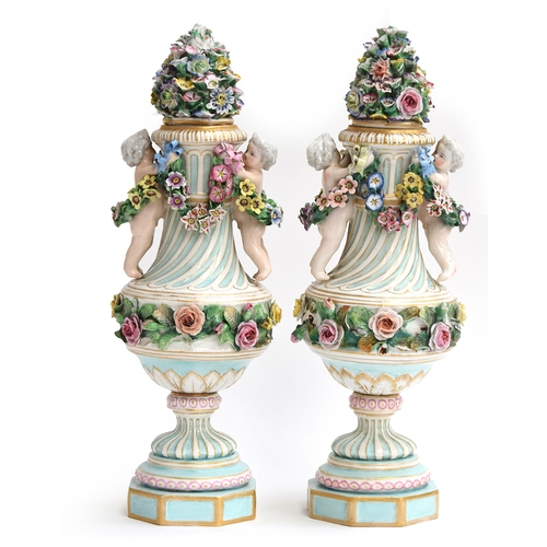 353 - A pair of 20th Century porcelain vases, each with flower-encrusted cover, the fluted urn-shaped bodi... 