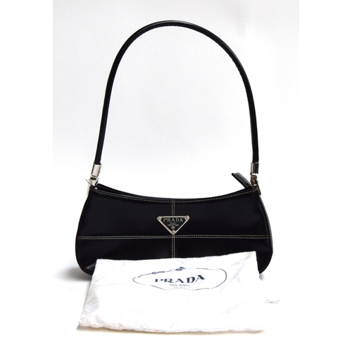 678 - Small firm black leather handbag from Prada with hinged silver hardware holding the handle, very goo... 