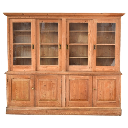 510 - A very large late Victorian pine dresser, with four sliding glazed doors, over a base with four pane... 