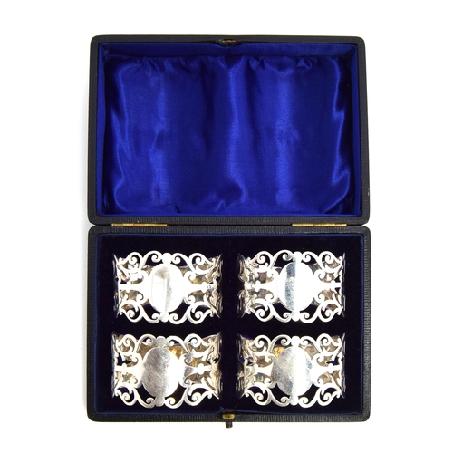 122 - A cased set of four silver napkin rings by Nathan Brothers, Birmingham 1904, with pierced scrolling ... 