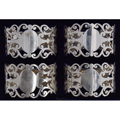 122 - A cased set of four silver napkin rings by Nathan Brothers, Birmingham 1904, with pierced scrolling ... 