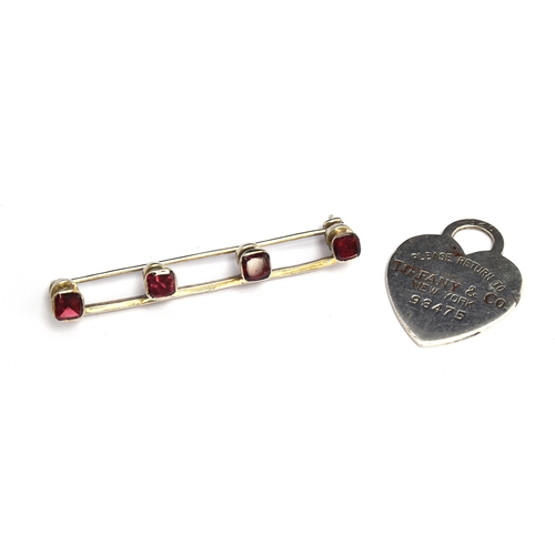 44 - A bar brooch set with four rubies; together with a Tiffany heart charm marked 'Please Return To Tiff... 