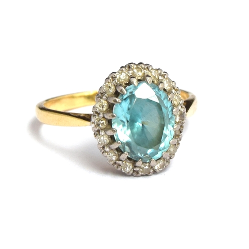 6 - An 18ct gold ring set with single aquamarine surrounded by small diamonds in an illusion setting, si... 