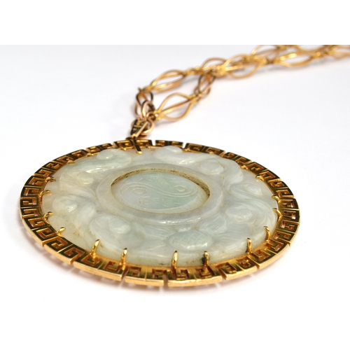 61 - Large jade pendant with central rotating disc with 9ct gold Greek key surround on a yellow metal cha... 