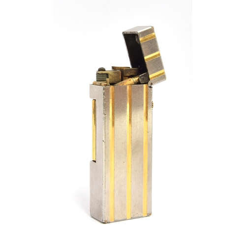 86 - A steel and gold plated Dunhill Rollagas lighter with indented gold stripes