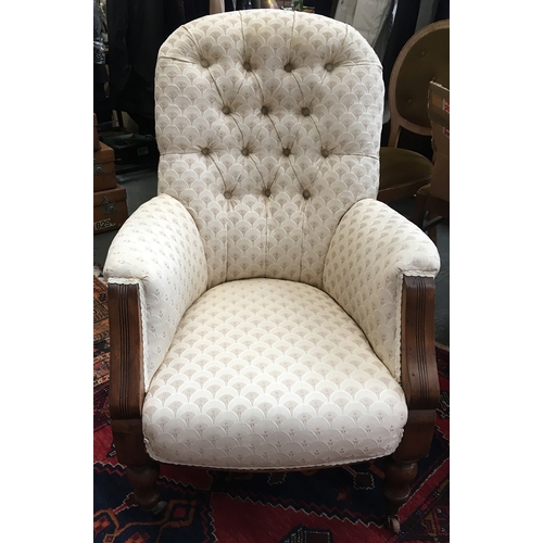 721 - A 19th century button back armchair on turned legs and casters