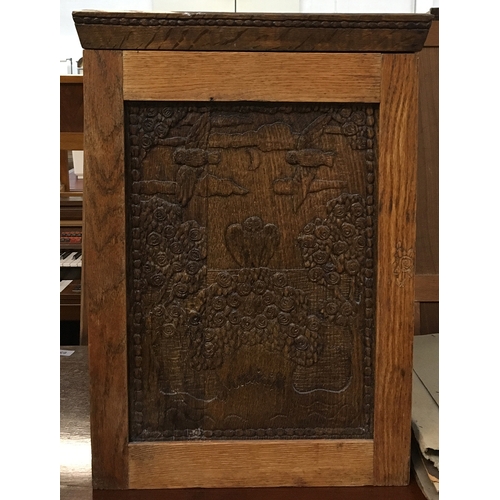 717 - An oak spice cupboard, the front carved with owls, opening to reveal two shelves and a drawer beneat... 