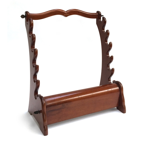 13 - A mahogany whip rack, having slots for six whips on curved supports above a rail for spurs, with sha... 