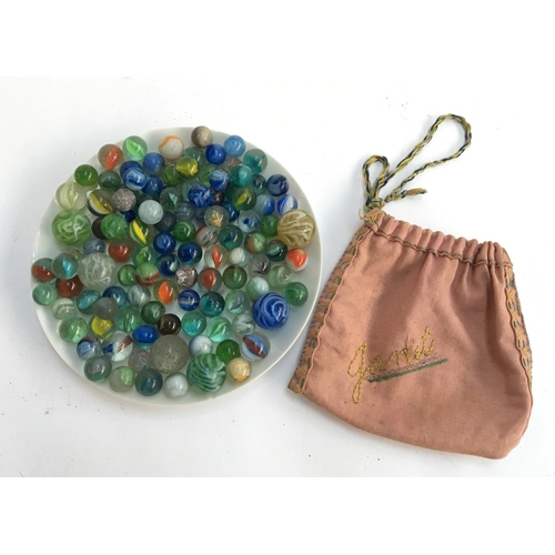 1063 - A collection of various marbles, mainly cats eye swirl, with embroidered storage pouch