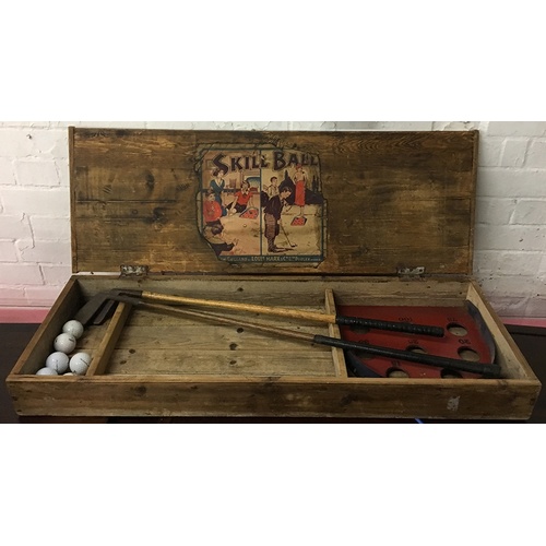 1073 - A 'Skill Ball' vintage putting game in wooden box containing two vintage golf clubs, 'British Made T... 