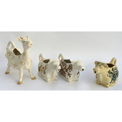 73 - A Beswick cow creamer decorated with floral pattern; together with two Crown Devon cow creamers and ... 