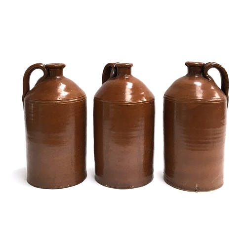 91 - A trio of stoneware flagons with loop handles and gouged pouring spout, 34cmH (3)