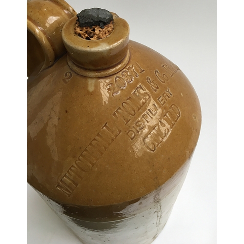 92 - A stoneware flagon with loop handle, marked 'Mitchell Toms & Co. ltd, distillery, Chard', 41cmH