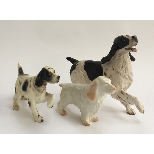 85 - A Belleek figurine of an Irish Setter, marked to base; together with two figurines of Spaniels (3)