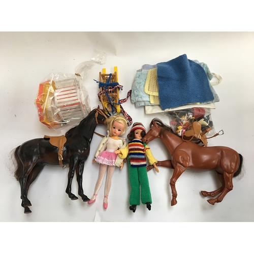 1022 - A box of Sindy dolls and accessories, to include two dolls, two horses, riding equipment etc