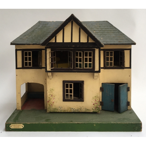 1025 - A Merigold Brothers 'Toyland' mock tudor dolls house; together with a foldable toy garage