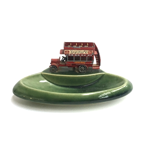 947 - A green ceramic Wade 'Yesteryears' pin dish surmounted by a die cast Matchbox double decker 'Dewar's... 