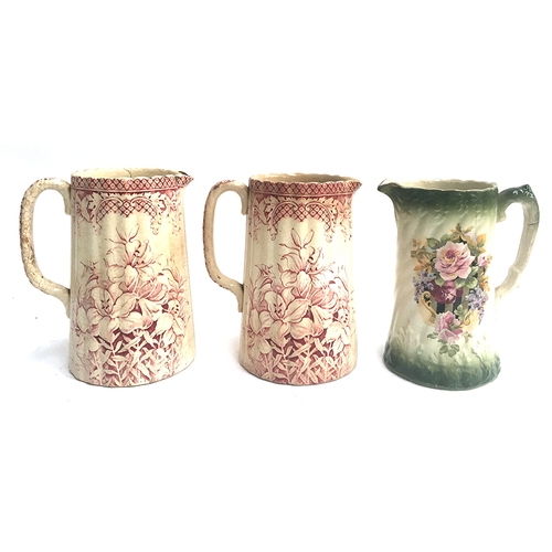 68 - A pair of ironstone transferware pitchers, decorated with burgundy lily design, each 20cmH; together... 