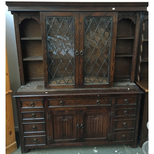 842 - A kitchen dresser with lead glazed central cabinet, sliding to reveal further cupboard, flanked by s... 