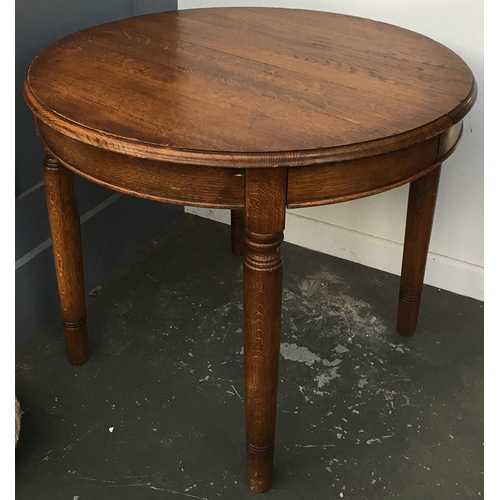 857 - A solid oak circular extending dining table, with spare leaf, 90cmD