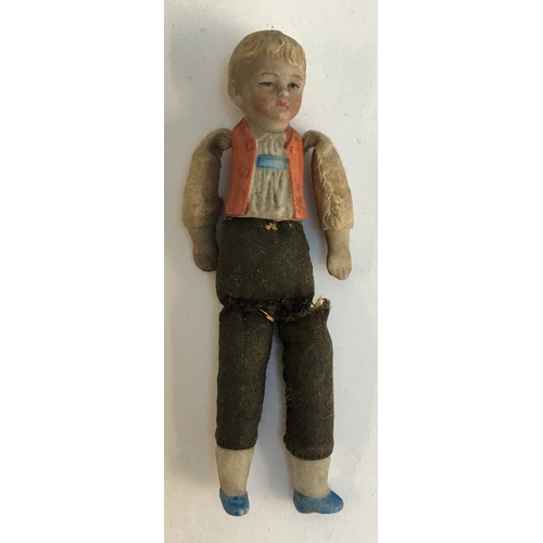 1027 - A very small early 20th century bisque doll of a young boy, with fabric torso, marked 'Germany' on r... 