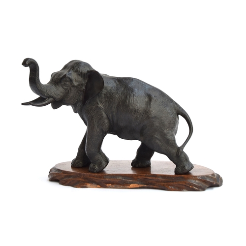 163 - A Japanese Meiji era bronze elephant, seal mark to underside, on carved hardwood base, 22cm high