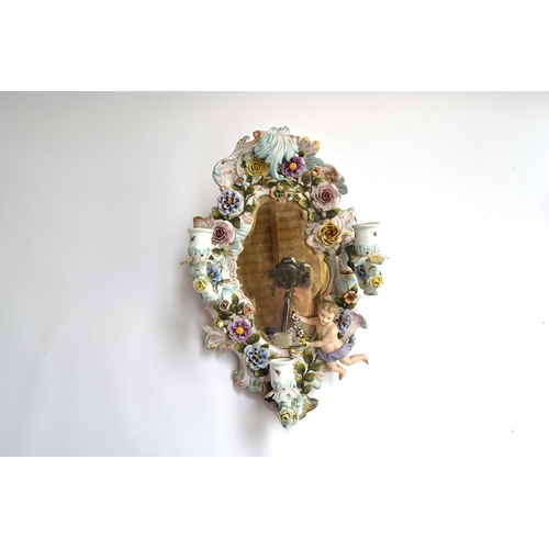 93 - A Sitzendorf wall mirror, with encrusted floral decoration alongside a cherub, with three removable ... 