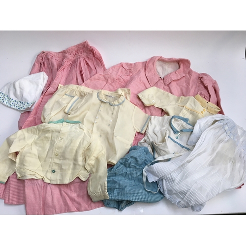 482 - A pink gingham jacket and skirt, together with various vintage baby outfits, some from Givans of New... 